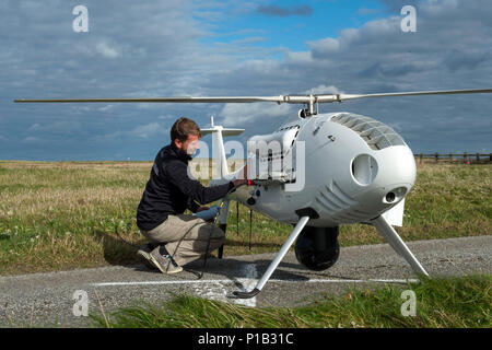 161012-N-JE 250-059 BENBECULA, Vereinigtes Königreich (Okt. 2010) 12, 2016) Marckus Hucik, einer S-100 CamCopter Unmanned Aerial Vehicle maintenance Operator, Wischtücher, die S-100, nachdem es in Benbecula Rangehead gelandet. Mehr als 40 internationale Teilnehmer aus anderen Marinen, der Industrie, der Wissenschaft und Forschung Labore sind in Schottland die Durchführung der ersten unbemannten Krieger, ein Forschungs- und Training übung entworfen, um zu prüfen, und die neuesten in autonomen marine Technologien bei gleichzeitiger Stärkung der internationalen Interoperabilität. Unbemannte Krieger ist Teil der Gemeinsamen Krieger, eine halbjährliche Stockfoto