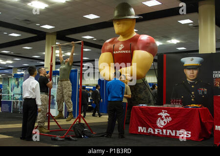 US-Marines beobachten Studenten, die während der Society of Asian Scientists and Engineers National Convention 2016 in Dallas, Texas, auf einer Karrieremesse mit Pull-ups spielen. Die Präsenz des Marine Corps demonstriert körperliche Fitness-Erwartungen und fördert das Bewusstsein für militärische Karrieren, während sie mit Studenten aus verschiedenen akademischen und kulturellen Hintergründen zusammenarbeitet. Stockfoto