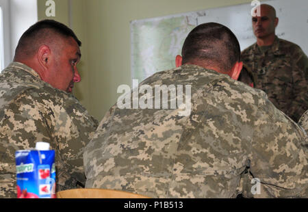 Eine ukrainische Soldaten spricht mit Sgt. 1. Klasse Michael Perez, Kommandant der Beobachter Trainer Trainer Akademie in das Joint Multinational Readiness Center zugeordnet, 7. Armee, Okt. 3, an der internationalen Friedenssicherung und Security Center in der Ukraine. Perez unterstützt die gemeinsame Multinationale Ausbildung Group-Ukraine mit Training 18 ukrainische Soldaten auf Beobachter Trainer Trainer Aufgaben. Der primäre Fokus des JMTG-U ist die direkte Ausbildung in der nahen Zukunft beim Helfen der ukrainischen Streitkräfte eine nachhaltige und dauerhafte Combat Training Center im IPSC zu errichten. Stockfoto