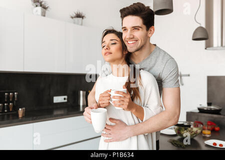 Porträt eines liebevollen jungen Paar trinken Kaffee in der Küche zu Hause. Stockfoto