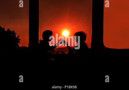 Romantische junge Menschen, die den Wein bei Sonnenuntergang im Dorf Sirince trinken Stockfoto