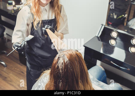 Weibliche Stilist, ein Farbstoff an die Clients Haare Beauty Salon Stockfoto