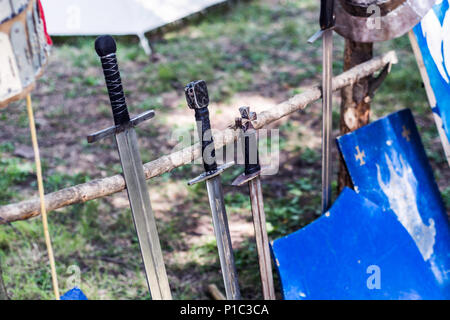 Arsenal der mittelalterlichen Ritter Schwert und Schild auf Holz Stativ. Mittelalter Konzept. Close Up, selektiver Fokus Stockfoto