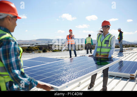 Ingenieure anheben solar panel an sonnigen Kraftwerk Stockfoto