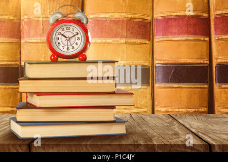 Das zusammengesetzte Bild im alten Wecker und Stapel von Büchern Stockfoto