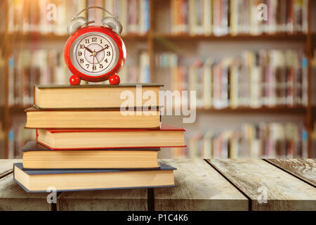 Das zusammengesetzte Bild im alten Wecker und Stapel von Büchern Stockfoto