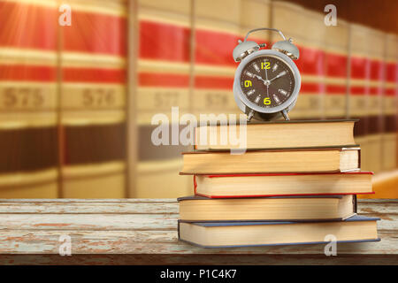 Das zusammengesetzte Bild von Wecker und Stapel von Büchern Stockfoto