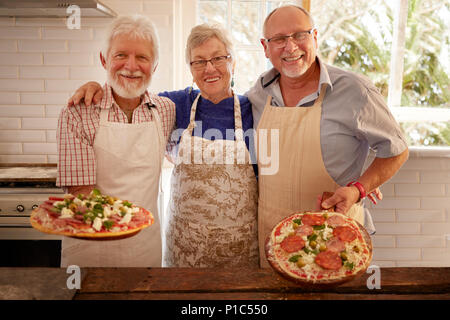 Porträt Lächeln, selbstbewussten älteren Freunde Pizza in Kochkurs Stockfoto