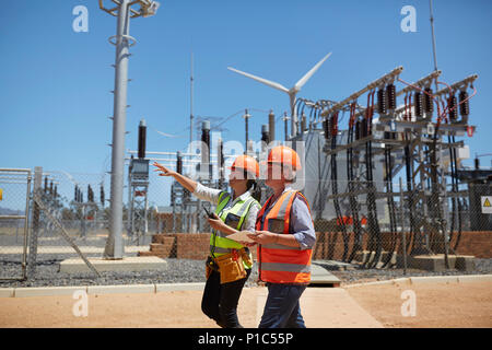 Weibliche Ingenieure mit digitalen Tablet bei Sunny Kraftwerk Stockfoto