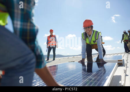 Ingenieure anheben solar panel an sonnigen Kraftwerk Stockfoto