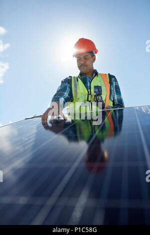 Techniker Prüfung solar panel an sonnigen Kraftwerk Stockfoto