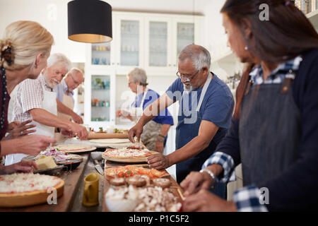 Ältere Freunde Pizzen im Kochkurs Stockfoto