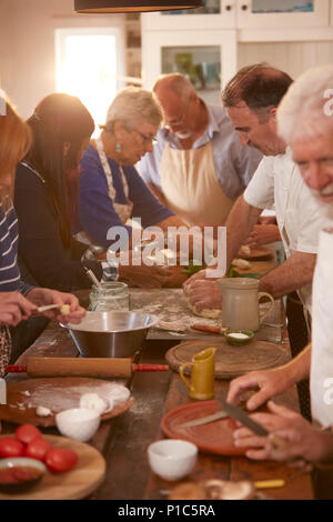 Active Senior Freunde Pizza in Kochkurs Stockfoto