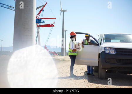 Arbeitnehmer sprechen bei Fahrzeug im Kraftwerk Stockfoto