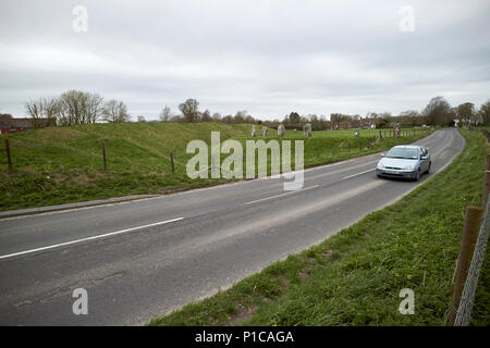 Auto fahren, ein 4361 Straße durch Henge aus kreisförmigen Bank und Graben um Steinkreis von Avebury avebury Wiltshire England Großbritannien Stockfoto