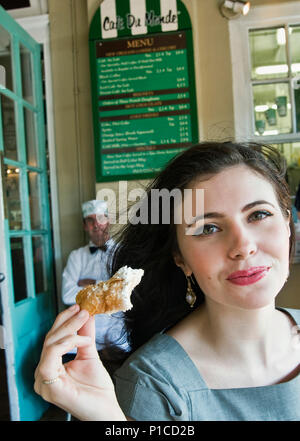 Eine Frau essen ein beignet im Cafe Du Monde in New Orleans, Louisiana Stockfoto