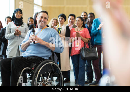 Publikum klatschen für Sprecher männlich im Rollstuhl Stockfoto