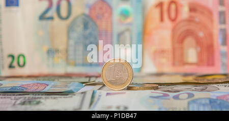 Finanzielle Dominanz: Ein Euro in einen Schraubstock ein, vor dem Hintergrund der amerikanischen Dollar und Euro mit Platz für Text. Stockfoto