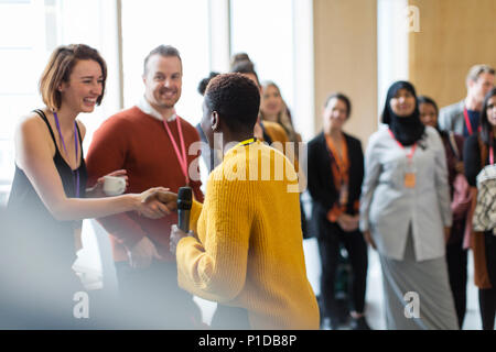 Geschäftsfrau Händeschütteln mit Lautsprecher bei Konferenz Stockfoto