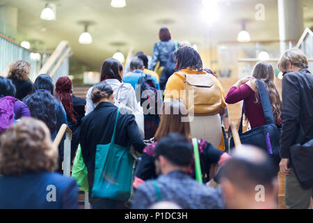Masse der Leute mit Rucksäcken und Taschen Treppensteigen Stockfoto