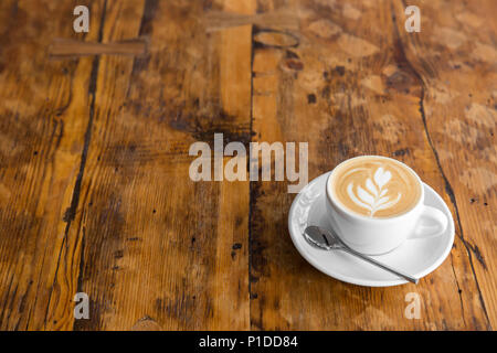 Tasse Kaffee zu gehen auf dem Holztisch mit Latte Art Street Kaffee. Kopieren Sie Platz Stockfoto