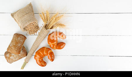 Brot Produkte, Ähren, Croissants, Ciabatta auf weißem Holz- Hintergrund. Kopieren Sie Platz. Ansicht von oben. Stockfoto