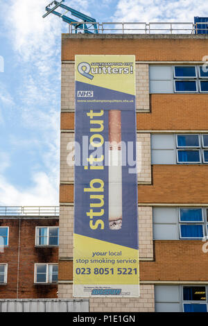 Die Wanne es heraus' Banner für die lokalen NHS "Drückeberger Stop Smoking service" sowie ein Gebäude am allgemeinen Krankenhaus in Southampton, England, Großbritannien Stockfoto