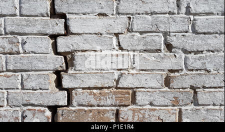 Hintergrund Textur Stein mauer, mit weißer Farbe mit einem tiefen Schwarz Riss auf der rechten Seite abgedeckt. Stockfoto