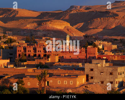 Traditionelle Berber Stadt bei Sonnenuntergang: Das rosa Strahlen der Sonne der Ton Gebäude in einem Tempo von Ton beleuchten, wie die umliegenden Berge, Marokko. Stockfoto