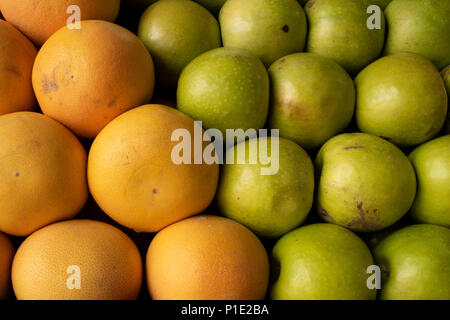 Riesige Orangen in einem hellen Dick schälen und grünen Äpfeln. Stockfoto