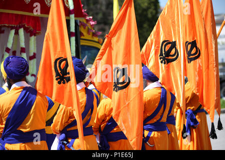 Sikh Männer mit orange Fahnen und symboll KHANDA genannt bei religiösen Ritus Stockfoto