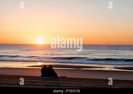 Strand Sonnenaufgang mit ein paar Stockfoto