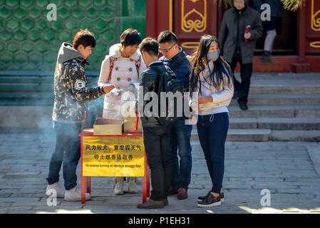 Peking, China - MÄRZ 10, 2016: Anbeter die Räucherstäbchen an Yonghegong Lamatempel in Peking, China, entzünden. Stockfoto