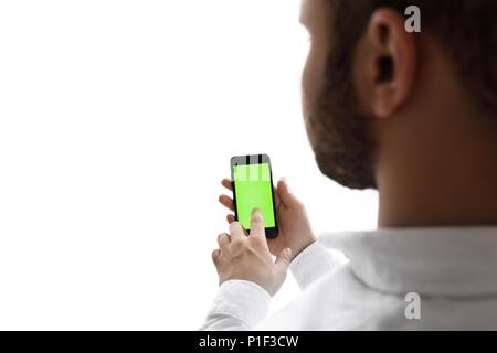Mann mit Handy beim Stehen in der Nähe der Fenster. Chroma Key Stockfoto
