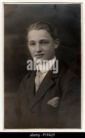 LIBEREC (REICHENBERG), TSCHECHOSLOWAKISCHE REPUBLIK - UM 1920s: Ein Vintage-Foto zeigt den jungen Mann, der eine Jacke mit Taschentuch in der Tasche trägt. Altes Schwarzweiß-Studioportrait. 1920s. Stockfoto