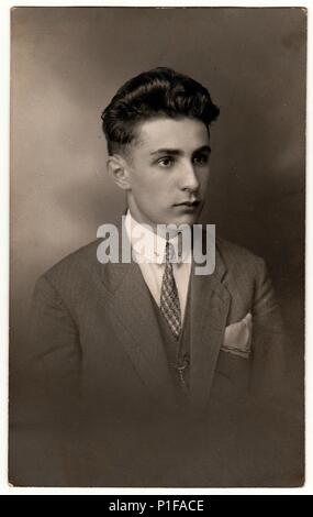 LIBEREC (REICHENBERG), TSCHECHOSLOWAKISCHE REPUBLIK - UM 1920s: Ein altes Foto zeigt den jungen Mann mit Jacke, Krawatte und Taschentuch in der Tasche. Antikes Schwarz-Weiß-Studioporträt. Vintage-Foto, 1920s. Stockfoto