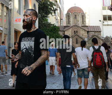 Ein Tätowierter Mann zu Fuß auf die Fußgängerzone Ermou Straße in Athen, Griechenland. Stockfoto