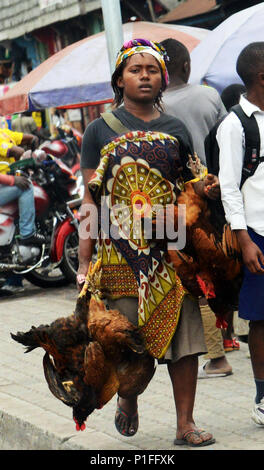 Eine kongolesische Frau, die lebende Hühner in der Hand. Stockfoto