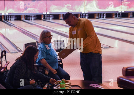 161030-N-SH 284-056 SILVERDALE, Washington (Okt. 30, 2016) Petty Officer 1st Class Pete Eala, von Honolulu, interagiert mit Athleten, als er Score während der Special Olympics bowling Turnier am All Star Gassen und Casino hält. Mehr als 28 Matrosen freiwillig, Set-up, clean-up, Score, Preisverleihungen und Helfen in Bahnen während der Veranstaltung halten, bewirtet von Special Olympics Washington das Jahr bietet - runde Sport und athletische Konkurrenz in einer Vielzahl von Olympischen - Typ Sport für Kinder und Erwachsene mit geistigen Behinderungen. (U.S. Marine Foto von Petty Officer 2. Klasse Vaughan Dill/Rele Stockfoto