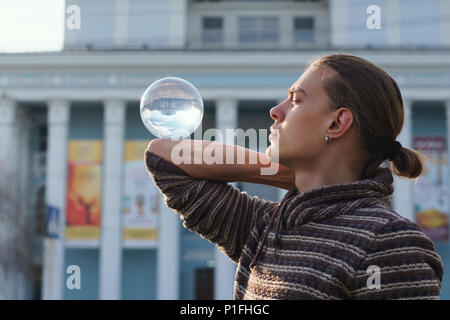 Kontakt Jonglage. Ein Mann steht auf der Straße der Stadt. Vor dem Hintergrund der architektonischen Strukturen. Stockfoto
