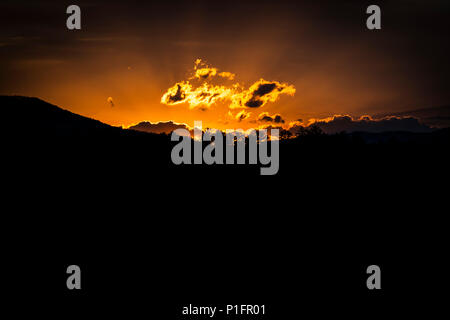 Horizontale Schuß eines leuchtenden Berge Sonnenaufgang mit einem schwarzen Vordergrund und Kopieren. Stockfoto