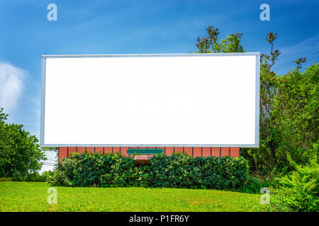 Horizontale geschossen von einem leeren neighorhood Billboard unter blauem Himmel, umgeben von Grün. Stockfoto