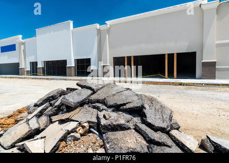 Neubau eines neuen Retail Strip Shopping Center. Große Datei von zerrissen Zahlung im Vordergrund. Stockfoto