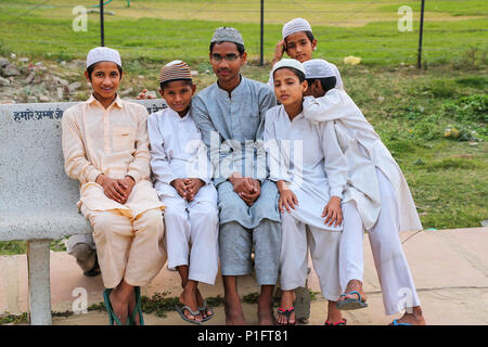 Lokalen Jungen sitzen auf einer Bank ausserhalb der Taj Mahal in Agra, Uttar Pradesh, Indien. Agra ist eines der bevölkerungsreichsten Städte in Uttar Pradesh Stockfoto