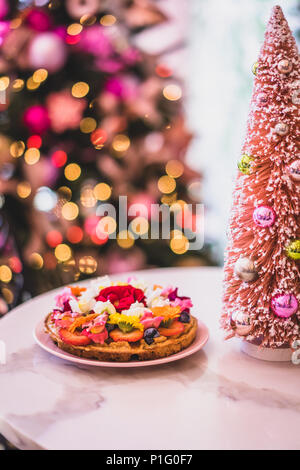 Waffeln mit Obst und Blumen auf einem Tisch mit bunten Weihnachtsdekor Stockfoto