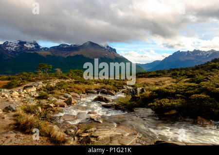 Ein kleiner Fluss steigt in der Nähe der Laguna Esmeralda. Das Tal und den Fluss bieten einen herrlichen Blick in eine schlammige Wanderung. Stockfoto