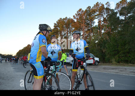 Von links, Team Navy Jax Radfahrer Ernie Mattison, Patrick Hall, und Bob Brassen das Fahrrad MS: PGA TOUR Zyklus zum Ufer weg, bevor er die Startlinie zu diskutieren. (U.S. Marine Foto von Petty Officer 2. Klasse Taylor Yori/Freigegeben) Stockfoto