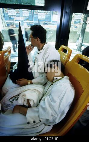 Spanien - Andalusien - La Vega (Sevilla) - Sevilla. nazarenos (Padre e) hijo de La Macarena agotados acabada La Madrugada; autobús. Stockfoto