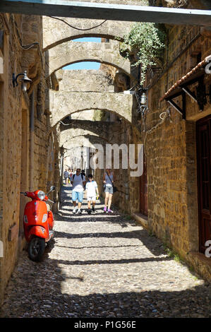 Rot. Ein rotes Motorrad auf der schmalen Straße von Rhodos Stockfoto