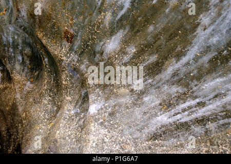 Die Wand einer Eishöhle hinter der Laguna de los Témpanos, nahe Ushuaia, hat atemberaubende goldene Texturen und weiße Linien. Stockfoto